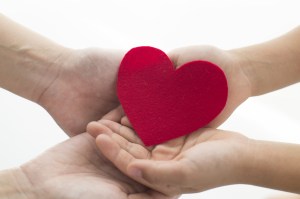 Hands of the mother and child to pass those heart-shaped