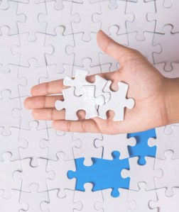 Young girl hand playing jigsaw puzzle