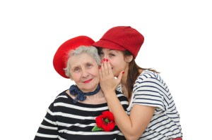 grandmother and her granddaughter whispering on white background
