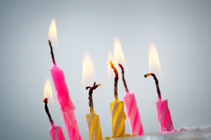 Six burning  birthday candles over grey background. Selective focus, shallow depth of field