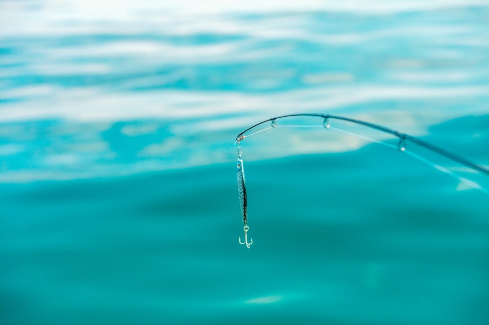 saltwater fishing - rod with wobbler and blue sea water